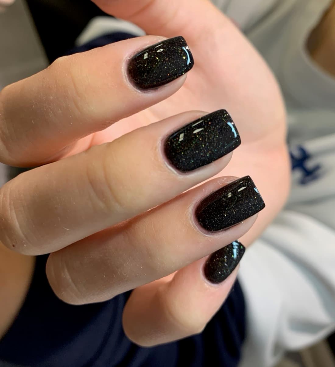 Black glitter gel manicure with a mirror finish from McAllister Spa's nail salon in Miami Beach