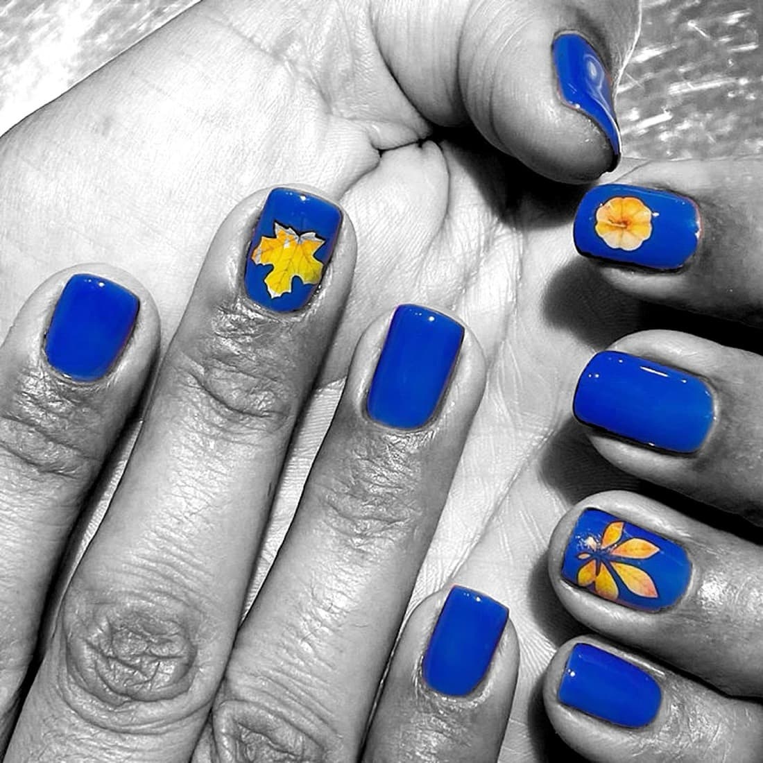 Cobalt blue manicure with hand-painted floral nail art by McAllister Spa's Miami Beach nail artists