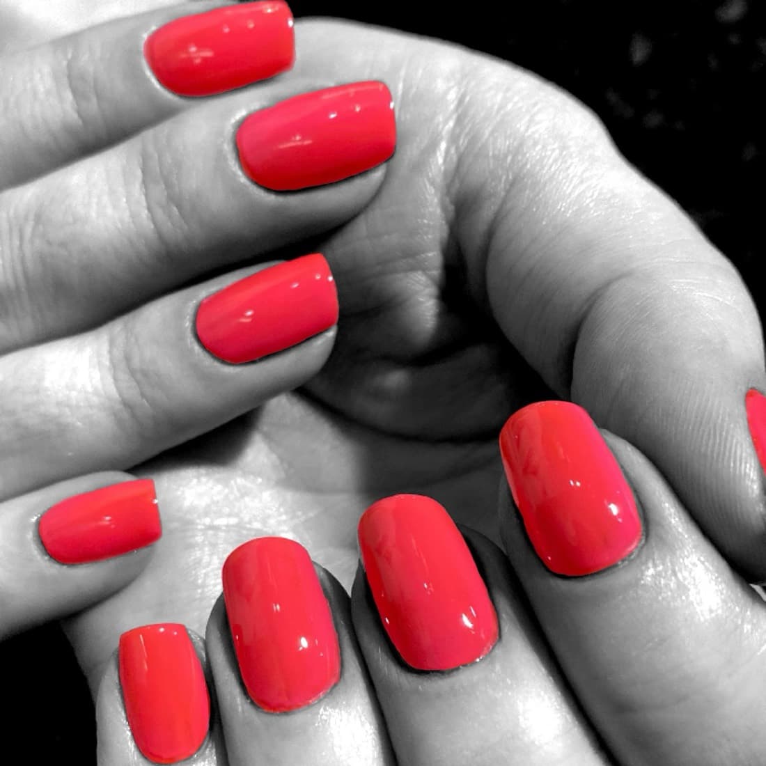 Coral red manicure shown on both hands at McAllister Spa's South Beach nail salon