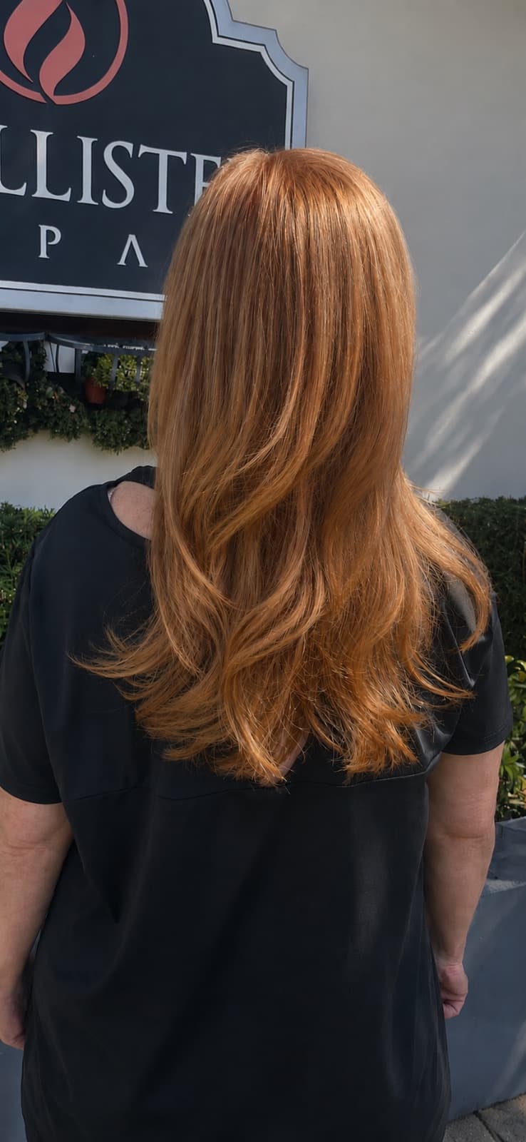 Long copper hair color with face-framing layers, outside McAllister Spa on Alton Road in Miami Beach