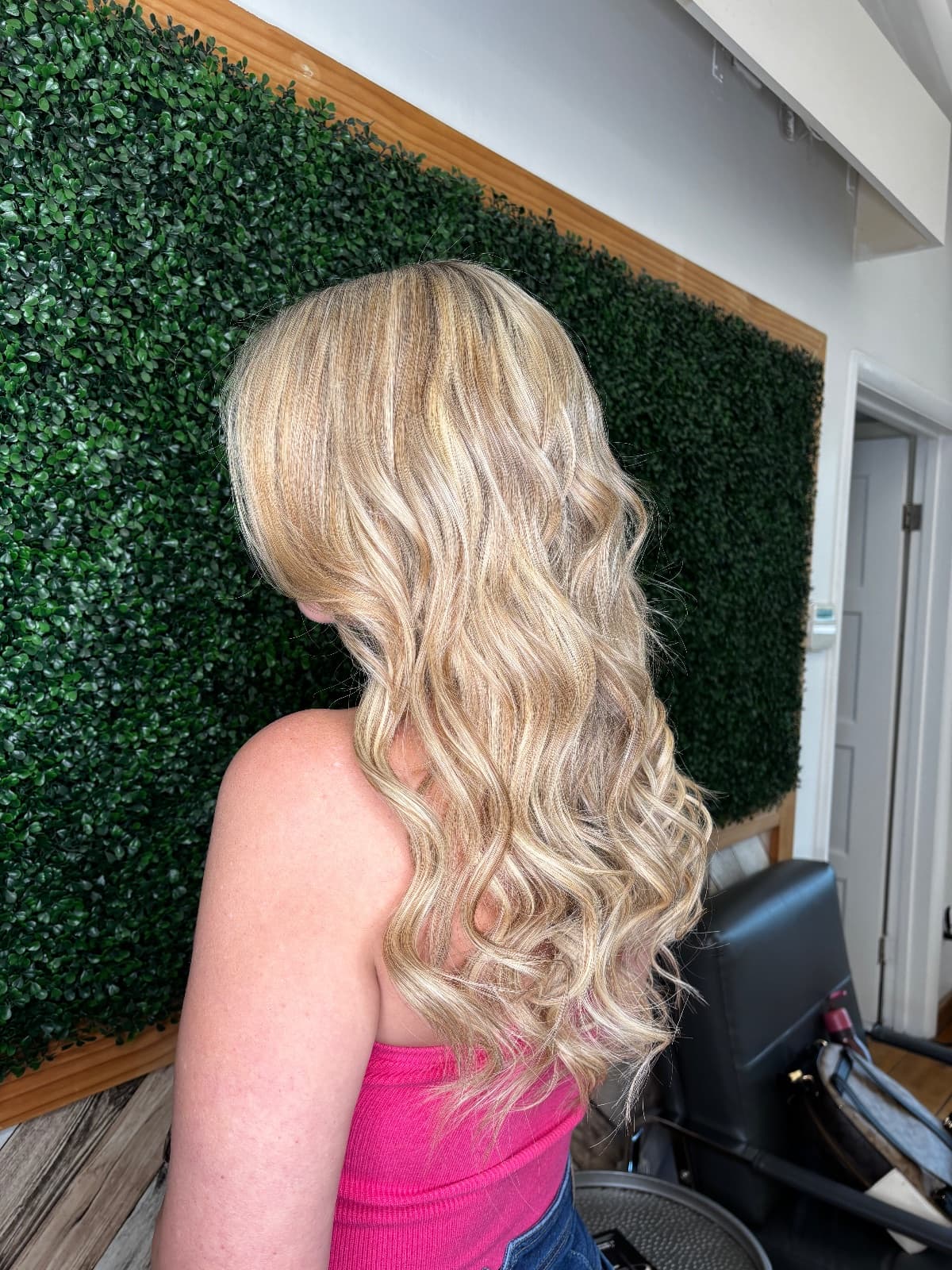 Buttery blonde highlights seen in profile, brushed into soft S-waves falling well past the shoulder — blonde color by Hali at McAllister Spa in South Beach
